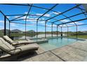 Gorgeous screened-in pool and spa with lake views and lounge chairs at 5226 Northern Flicker Dr, St Cloud, FL 34771