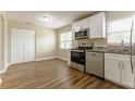 Updated kitchen boasts white cabinets, stainless steel appliances, granite countertops and wood-look floors at 5822 Flori Ln, Orlando, FL 32808
