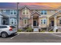Two-story townhome showcasing colorful exteriors, covered porches, and black railings at 6611 Time Square Ave # 103, Orlando, FL 32835