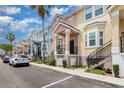 Street view of colorful two-story townhomes, showcasing their covered porches and black railings at 6611 Time Square Ave # 103, Orlando, FL 32835