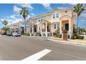 Street view featuring a row of colorful two-story townhomes, each with covered porches and manicured landscaping at 6611 Time Square Ave # 103, Orlando, FL 32835