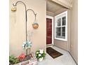 Charming entryway with decorative accents, flowers, and red door, creating a welcoming atmosphere at 677 Post Oak Cir # 115, Altamonte Springs, FL 32701