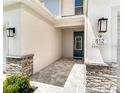 Inviting entrance with stone accents, modern lighting, and a stylish blue front door at 812 Driving Range Ct, Reunion, FL 34747