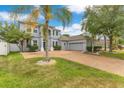 Well-maintained two-story home with a brick driveway, green lawn, and attached two-car garage at 8676 Currituck Sound Ln, Orlando, FL 32829