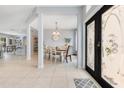 Inviting foyer with tile flooring, decorative glass front doors, and a view into the formal dining area at 8676 Currituck Sound Ln, Orlando, FL 32829
