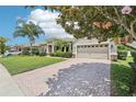 Beautiful home featuring a brick driveway, well-maintained lawn, and a three-car garage at 9843 Nokay Dr, Orlando, FL 32836