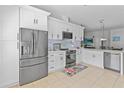 Bright kitchen with white cabinets, stainless steel appliances, and a breakfast bar overlooking the dining area at 10124 Pink Carnation Ct, Orlando, FL 32825