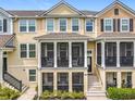 Close up of three-story townhome featuring screened porch, stairs leading to the entry, and well-kept landscaping at 1027 Cedar Bay Ln, Winter Springs, FL 32708