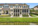 Three-story townhome with screened porches, situated along a pond, offering a relaxing outdoor space and waterfront view at 1027 Cedar Bay Ln, Winter Springs, FL 32708