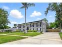 Spacious two-story home with long driveway, lush lawn, and symmetrical window and shutter design at 103 Cherry Hill Cir, Longwood, FL 32779