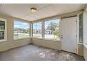 Bright screened porch offering a view of the neighborhood, freshly painted with a front door at 108 N Truett St, Leesburg, FL 34748