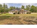 Well-maintained single story home with lush green grass and mature trees in the background at 13780 Sw 78Th Pl, Dunnellon, FL 34432