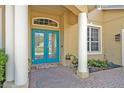 Close-up of an elegant entryway showcasing a blue double door framed by white columns and brick paving at 14545 Braddock Oak Dr, Orlando, FL 32837