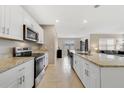 Well-lit kitchen featuring a breakfast bar, granite countertops and stainless steel appliances at 1511 Barberry Dr, Kissimmee, FL 34744