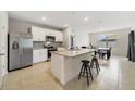 Bright kitchen featuring stainless steel appliances, white cabinetry, and a central island with barstool seating at 1511 Barberry Dr, Kissimmee, FL 34744