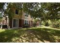 Backyard view featuring a grassy lawn and the building's exterior, complemented by mature trees and landscaping at 15349 Oak Apple Ct # B, Winter Garden, FL 34787