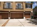 Townhouse showcasing attached garages, ample parking, and a neutral exterior paint scheme under a sunny sky at 15349 Oak Apple Ct # B, Winter Garden, FL 34787