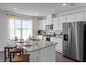 Bright kitchen featuring a granite island with seating and stainless steel appliances at 1562 Dalehurst Ln, Kissimmee, FL 34744