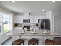 Modern kitchen featuring a large island with seating, stainless steel appliances, and ample cabinet space at 1562 Dalehurst Ln, Kissimmee, FL 34744