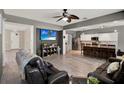 Spacious living room with hardwood floors, gray walls, a ceiling fan, and a kitchen view at 1744 Pine Ridge Dr, Davenport, FL 33896