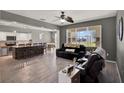 Open-concept living room boasts hardwood floors, and modern lighting, seamlessly connected to a kitchen and dining area at 1744 Pine Ridge Dr, Davenport, FL 33896