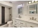 Beautifully updated bathroom featuring dual sinks, marble countertop, modern fixtures, and a tiled shower with a glass door at 209 Sweet Gum Way, Longwood, FL 32779
