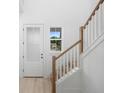 Bright foyer with a light wood floor, stairway with wood handrail, and a frosted glass front door at 2137 Brighton Ln, Orlando, FL 32817