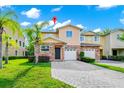 Charming townhome featuring a stone facade, two-car garage, and well-manicured landscaping at 2157 Cypress Villas Dr, Orlando, FL 32825