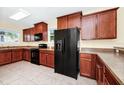 Well-equipped kitchen with dark wood cabinets, black appliances, and tiled flooring at 2157 Cypress Villas Dr, Orlando, FL 32825