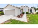 Charming home featuring a garage and well-manicured lawn, exuding curb appeal with beautiful walkway at 25409 Waterbrook Ct, Leesburg, FL 34748