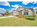 Well-maintained single-story home with a lush green lawn and colorful landscaping at 2541 Bobby Lee Ln, St Cloud, FL 34772