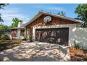 One-story house with a spacious driveway, a two-car garage with a basketball hoop and stone details at 2708 Burton Ln, Orlando, FL 32817