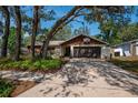 Inviting single-story home with well-maintained lawn and a two-car garage, shaded by mature trees at 2708 Burton Ln, Orlando, FL 32817