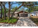 Alluring one-story home showcasing a lush front yard, a driveway, and a two-car garage, shaded by trees at 2708 Burton Ln, Orlando, FL 32817