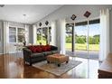 Bright living room with hardwood floors, large windows offering scenic views, and comfortable seating, perfect for relaxation at 3008 Pinnacle Ct, Clermont, FL 34711