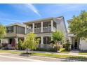 Gray two-story home with double porch, white railing, and well-maintained landscaping at 308 Michael Blake Blvd, Winter Springs, FL 32708