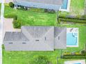An aerial shot of a home with a gray roof, green lawn, and a pool in the backyard at 311 W Falls Dr, Kissimmee, FL 34747