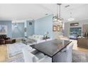 Open-concept living and dining area with light blue walls, hardwood floors, and access to the pool at 3285 Majestic Oak Dr, St Cloud, FL 34771