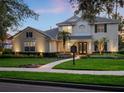 Charming two-story home with a landscaped front yard, illuminated walkway and welcoming double-door entrance at 3352 Park Grove Ct, Longwood, FL 32779