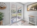 Bright entryway featuring white wood-look flooring, decorative accents, and a view to the screened porch at 3714 Paige St, Port Orange, FL 32127