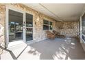 Inviting covered porch showcasing charming wicker furniture and stone accent wall, ideal for relaxation at 3714 Paige St, Port Orange, FL 32127
