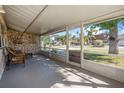 Relaxing screened-in porch with stone wall, providing a cozy outdoor living space with neighborhood view at 3714 Paige St, Port Orange, FL 32127