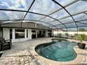 Relaxing screened-in pool area featuring a brick-paved deck, perfect for outdoor entertaining at 4297 Abaco Dr, Tavares, FL 32778