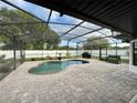 Gorgeous screened-in pool with a stone-paved deck and a well-maintained fenced yard at 4297 Abaco Dr, Tavares, FL 32778