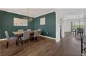 Formal dining room featuring dark green walls, hardwood floors, and stylish chandelier and view to second dining area at 455 Lazio Cir, Debary, FL 32713