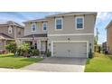 Charming two-story home with a manicured lawn and a brick-paved driveway leading to a two-car garage at 455 Lazio Cir, Debary, FL 32713