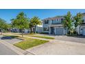 View of the lovely gray townhomes that have manicured lawns and elegant tree lined streets at 4807 Kings Castle Cir, Kissimmee, FL 34746