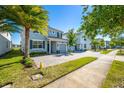Charming gray townhome featuring an attached garage, green lawn, and tree-lined street at 4807 Kings Castle Cir, Kissimmee, FL 34746