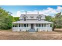 Charming two-story home with a metal roof and inviting wrap-around porch at 511 E Mirror Lake Dr, Fruitland Park, FL 34731