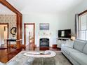Bright living room featuring hardwood floors, a decorative fireplace, and neutral-toned furniture at 511 E Mirror Lake Dr, Fruitland Park, FL 34731
